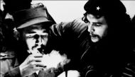 (FILES) This file photo taken in the 60s shows then Cuban Prime Minister Fidel Castro (L) lighting a cigar while listening to Argentine Ernesto Che Guevara. Cuban revolutionary icon Fidel Castro died late on November 25, 2016 in Havana, his brother, Presi