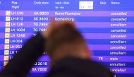 A flight passenger stands in front of a board displaying cancelled flights of German airline Lufthansa on November 25, 2016 at the airport in Frankfurt am Main, western Germany. Germany OUT / AFP / dpa / Arne Dedert