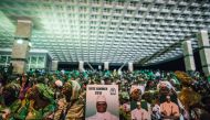 Supporters of incumbent Gambian President Yahya Jammeh hold a placard reading 'Vote Jammeh' in Banjul on November 29, 2016, during the closing rally of the electoral campaign of the Alliance for Patriotic Reorientation and Construction (APRC). AFP / MARCO