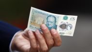 Bank of England governor Mark Carney poses with a new polymer five pound note at Whitecross Street Market in London, Britain September 13, 2016. (REUTERS/Stefan Wermuth/File Photo)