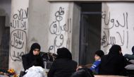 Syrians evacuated from eastern Aleppo, rest inside a shelter in government controlled Jibreen area in Aleppo, Syria December 1, 2016. Writings on the wall read in Arabic, 