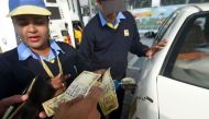 An Indian customer pays for fuel with old 500 rupee notes at a petrol station in New Delhi on December 2, 2016, the last day on which the old currency can be used to purchase fuel. AFP / Dominique Faget 