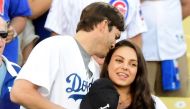 This file photo taken on October 18, 2016 shows Ashton Kutcher and wife Mila Kunis on the field after they announced the Los Angeles Dodgers starting lineup before game four of the National League Championship Series againt the Chicago Cubs at Dodger Stad