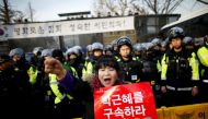 A woman chants slogans in front of riot policemen as they march toward the Presidential Blue House during a protest calling for South Korean President Park Geun-hye to step down in central Seoul, South Korea, December 3, 2016. The sign reads: 