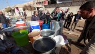 Iraqi people collect water in Mosul, Iraq, December 3, 2016. REUTERS/Alaa Al-Marjani