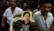 A supporter of Tamil Nadu Chief Minister Jayalalithaa Jayaraman holds her photo at the AIADMK party office in Mumbai, India, December 5, 2016. REUTERS/Danish Siddiqui