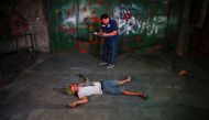  An investigator takes notes next to the body of a man killed in a shoot-out with police in Manila Philippines early October 21 2016