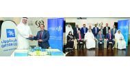 LEFT: Commercial Bank CEO Joseph Abraham (right) exchanging documents with Yasser Salah Al Jaidah, Chief Executive Officer of Qatar Cool, during the signing ceremony. RIGHT: Officials of Commercial Bank and Qatar Cool pose for a group picture. 