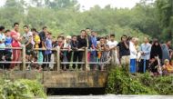 People watch as rescue workers search for two boys who went missing during a flash flood in the southern Thai province of Pattani, on December 6, 2016. - AFP