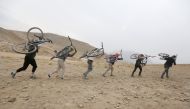 Young Afghan cyclists carry their bicycles on their back on a hill during an exercise on the outskirts of Kabul, Afghanistan November 20, 2016. REUTERS/Omar Sobhani
