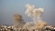 A picture taken from a rebel-held area shows smoke billowing from buidings in the pro-regime Shiite town of Fuaa, in northwestern Idlib province, on December 6, 2016 following a reported rebel shelling.  AFP / Omar haj kadour