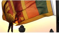 An air force officer holds Sri Lanka's national flag as the sun sets at Galle Face Green in Colombo February 2, 2013. REUTERS/Dinuka Liyanawatte