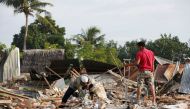 Men look for items to salvage from a building which collapsed following this week's strong earthquake in Pidie Jaya, Aceh province, Indonesia December 10, 2016. REUTERS/Darren Whiteside
