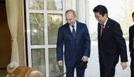 Russian President Vladimir Putin and his dog named Yume, which was presented to Putin by Japan's northern Akita Prefecture in July 2012, welcome Japanese Prime Minister Shinzo Abe upon Abe's arrival for their meeting in Sochi, Russia, in this photo taken 