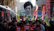An effigy of South Korean President Park Geun-hye is seen behind people marching towards the Presidential Blue House during a protest calling for South Korean President Park Geun-hye to step down in central Seoul, South Korea, December 10, 2016. The signs