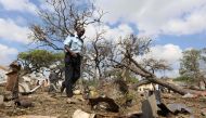 A security officer walks past a temporary stall destroyed after a suicide car bomb went off at the entrance of Somalia's biggest port in its capital Mogadishu December 11, 2016. REUTERS/Feisal Omar
