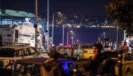 Turkish police officers and forensic work next to damaged police vehicles and cars on the site where a car bomb exploded near the stadium of football club Besiktas in central Istanbul on December 10, 2016. The car bomb exploded in the heart of Istanbul on