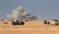 Smoke billows in the back as Shiite fighters from the Hashed al-Shaabi (Popular Mobilisation) paramilitary forces advance towards the Iraqi town Jamaat Hussein, west of Mosul, on December 11, 2016, during an ongoing operation against Islamic State (IS) gr