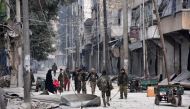 Syrian pro-government forces patrol Aleppo's eastern al-Salihin neighbourhood on December 12, 2016 after troops retook the area from rebel fighters. / AFP / GEORGE OURFALIAN