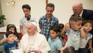 Pope Francis reading a book to Syrian refugee children at  Vatican (AFP) 