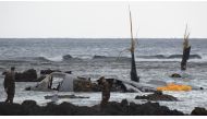 The wreckage of a US Marine MV-22 Osprey tilt-rotor aircraft is seen as the tide recedes on the coast of Nago, Japan's southern island of Okinawa on December 14, 2016, after it crash landed in shallow waters late December 13. Japan OUT / AFP / JIJI PRESS 