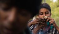 (FILES) In this photograph taken on September 7, 2015, an Indian youth who works as a ragpicker sniffs a cloth soaked in glue near the Hazrat Nizamuddin Railway station in New Delhi.  AFP
