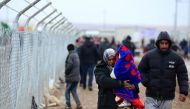 MOSUL, IRAQ - DECEMBER 14: Internally relocated Iraqi people walk near fence as they are facing lack of clean water, heating and electricity problems at the Khazir refugee camp in the Hasan Sam village near Mosul, Iraq on December 14, 2016. ( Hamit Hüseyi