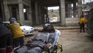 n injured Syrian man from Aleppo waits on a stretcher as he is being transported from the Syrian side of the Bab al-Hawa border crossing to a hospital in Turkey on December 16, 2016. The Syrian government suspended the evacuation of the last rebel-held pa