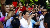 President Rodrigo Duterte poses for selfies with Filipinos after an orchid naming ceremony at Singapore Botanic Gardens, yesterday.