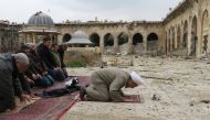 Syrians pray in the ancient Umayyad mosque in the old city of Aleppo on December 17, 2016, as civilians are allowed access to some neighbourhoods recently retaken by Syrian government forces. AFP