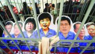 Portraits of South Korea's President Park Geun-hye and her aides are set in a mock prison during a rally in Seoul, yesterday.