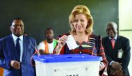 Ivory Coast's First Lady Dominique Ouattara casts her ballot next to the President of the Independent Election Commission Youssouf Bakayoko (left) at a polling station in Cocody, a commune of Abidjan, yesterday.