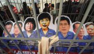 Portraits of South Korea's President Park Geun-Hye (C) and her aides are set in a mock prison during a rally against the scandal-hit president in central Seoul on December 17, 2016. AFP / JUNG Yeon-Je
