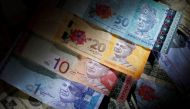 Malaysia's ringgit touched the lowest level since the Asian financial crisis as investors continue to sell down emerging-market assets and after a crackdown on currency speculators last month exacerbated outflows. PHOTO: REUTERS.