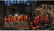 Workers search through the remains of a collapsed platform in a cooling tower at a power station at Fengcheng in China's Jiangxi province on November 24, 2016. The death toll from a collapse at a power station under construction in China rose to 74, state