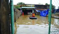 A boy leaves his flooded home on a rubber tyre tube in the central province of Binh Dinh.