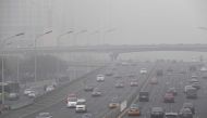 Smog hangs over a road on a polluted day in Beijing on December 20, 2016. AFP / Greg Baker