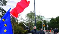 A man waves a Polish flag during an anti-government demonstration of opposition parties suporters and Committee for the Defence of Democracy movement (KOD) in Warsaw, yesterday.
