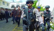 Jakarta's governor Basuki Tjahaja Purnama is escorted by anti-terror police as he leaves the North Jakarta court, yesterday.