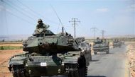 Turkish troops drive their tanks on a road near the Syrian village of al-Waqf and some 3km south of al-Rai. AFP photo.
