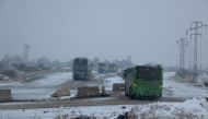 ALEPPO, SYRIA - DECEMBER 21: A convoy, evacuating civilians who flee from Assad regime supporter foreign terrorists controlled Fua and Kefraya towns those had been under siege by opposition groups, move forward Assad regime controlled western rural parts 