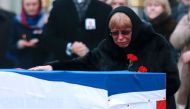 Marina Davydova Karlova, widow of late Russian Ambassador to Turkey Andrei Karlov, reacts in front of his coffin, during a ceremonial farewell with full state honours on the tarmac of Ankara's Esenboga Airport on December 20, 2016, before the coffin is tr