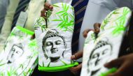 A Sri Lankan customs officer displays oven gloves from an impounded stock of kitchen aprons from India featuring images of the Buddha, in Colombo, yesterday.