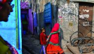 A young girl and her mother walks out of an alley in the Kathputli Colony in New Delhi, yesterday.