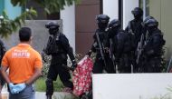 Indonesian anti-terror police from Detachment 88 carry a bag containing a suspected firearm and other evidence from a building during a raid in Batam, Riau Islands, Indonesia, August 5, 2016 in this photo taken by Antara Foto. Antara Foto/M N Kanwa/via RE