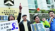 Pro-democracy demonstrators holding portraits of Chinese disbarred lawyer Jiang Tianyong, demanding his release, during a demonstration outside the Chinese Liaison Office in Hong Kong, yesterday.