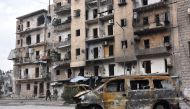 Syrians government forces walk past destroyed buildings in the former rebel-held Ansari district in the northern Syrian city of Aleppo on December 23, 2016 after regime forces retook control of the whole embattled city.  AFP / George OURFALIAN