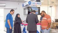 A QIC Insured staff assisting customers at  a Self Service counter in Abu Hamour. 