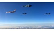 (FILES) This file video grab made on March 15, 2016 shows an image taken from a footage made available on the Russian Defence Ministry's official website reportedly showing Russian Su-34 bombers and a Tupolev Tu-154 transport plane (L) flying above an unk