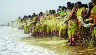Women throw flowers into the sea as an offering during a ceremony for the victims of the 2004 tsunami at Marina Beach in Chennai yesterday.